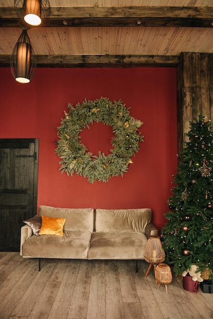 Stylish interior of the living room with a Christmas tree on a red background