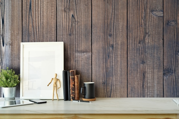 Stylish interior with mock up blank poster frame, plant, vintage books and copy space