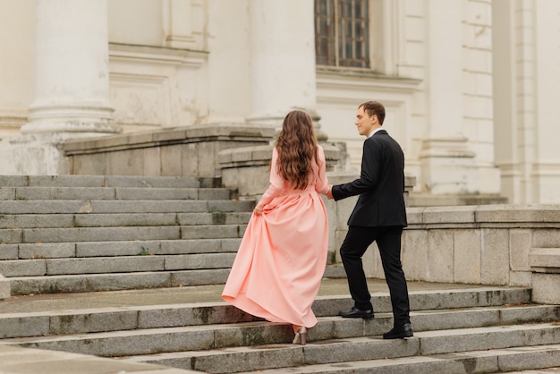 Stylish Just merried. wedding couple.Close up. Happy bride and groom walking near old castle. Bridal wedding bouquet of flower