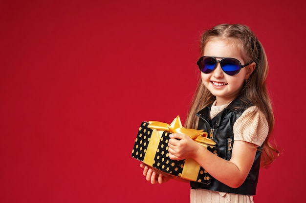 Stylish little girl with a gift box