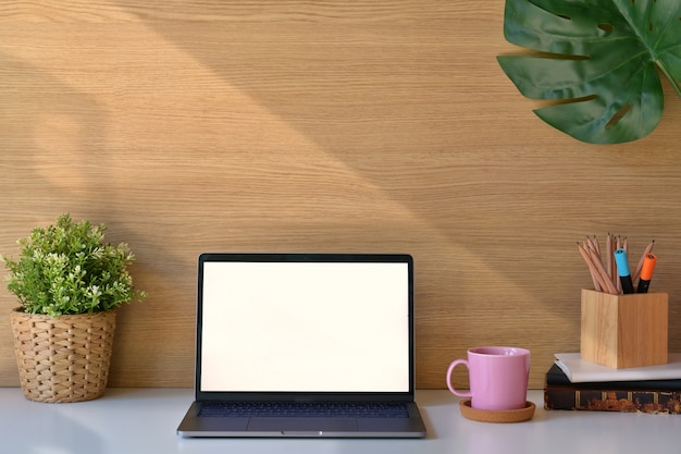 Stylish loft workspace with white screen laptop. 