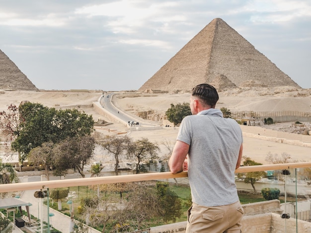 Stylish man against the background of the Giza pyramids