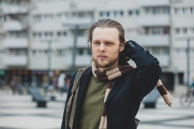 Stylish man in coat and scarf at city street of Wroclaw Poland