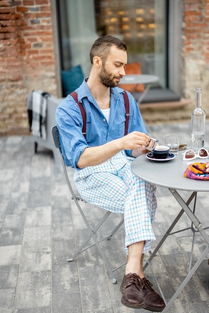 Stylish man drinks coffee at cafe