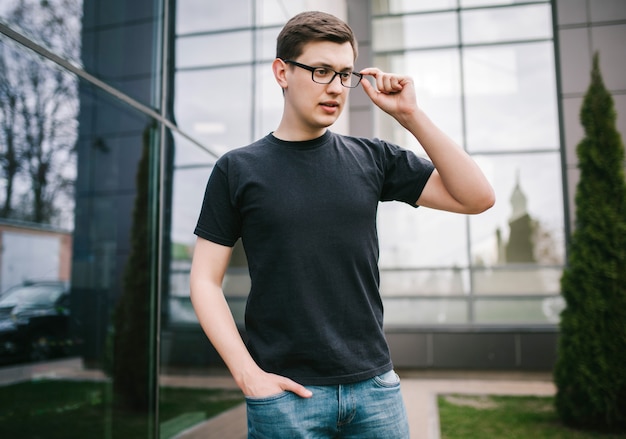 A stylish man in glasses and black T-shirt. Street photo