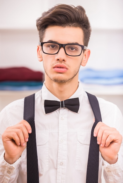 Stylish man in glasses standing in dressing room.