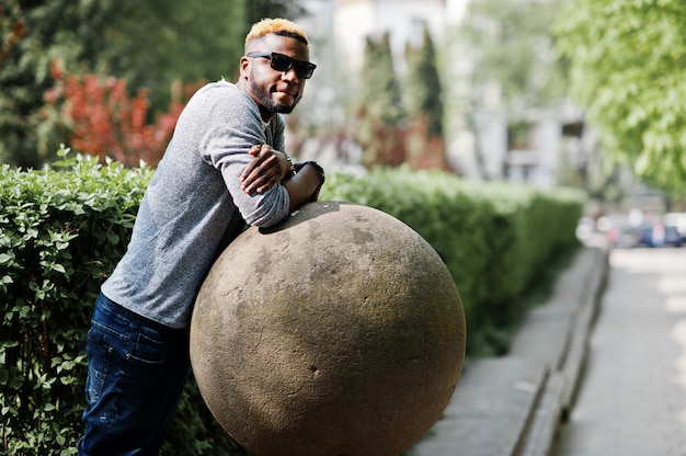 Stylish man on gray sweater and black sunglasses posed on street