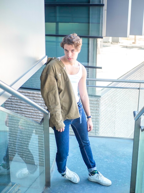 Stylish man standing near glass railings of modern building