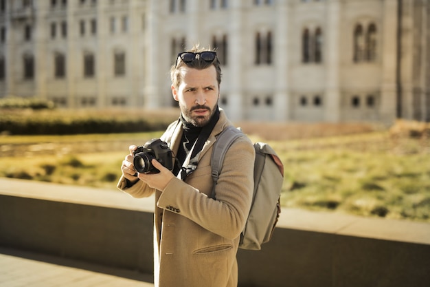 Stylish man walking with a camera