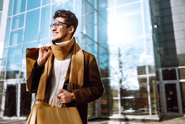 Stylish man with paper packages after shopping Sale consumerist lifestyle concept