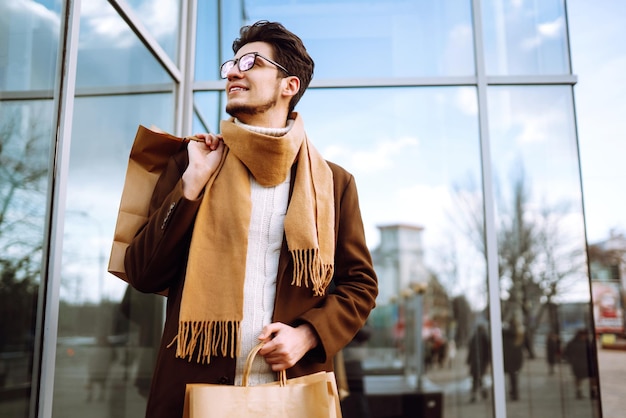 Stylish man with paper packages after shopping Sale consumerist lifestyle concept