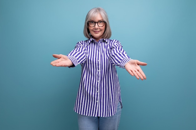 Stylish mature old lady in a trendy shirt on a bright studio background with copyspace