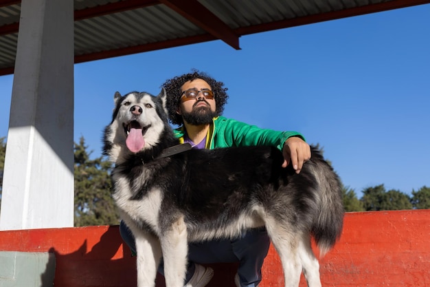 Stylish Mexican man with his dog in a park in Mexico City