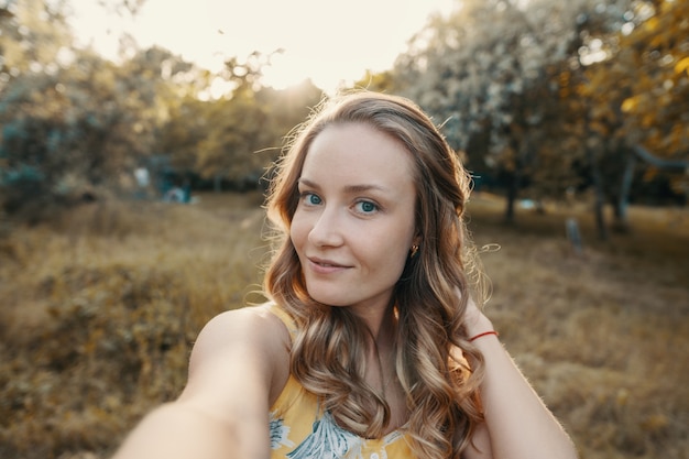 Stylish modern girl taking a selfie out in the park.