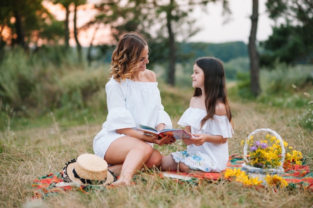 Stylish mother and handsome daughter having fun on the nature