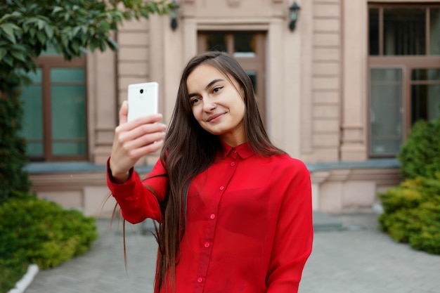 stylish outfit making selfie Portrait of beautiful young woman visiting a destination city