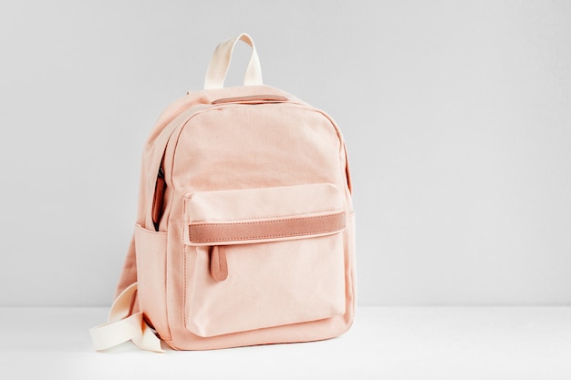 Stylish pale pink Backpack on  with background. Flat lay, top view