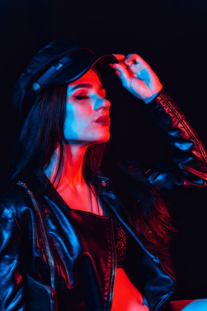 Stylish Portrait of a young woman in a leather jacket and cap