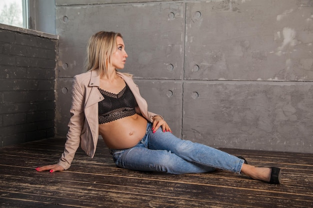 Stylish pregnant blonde in jeans modern motherhood