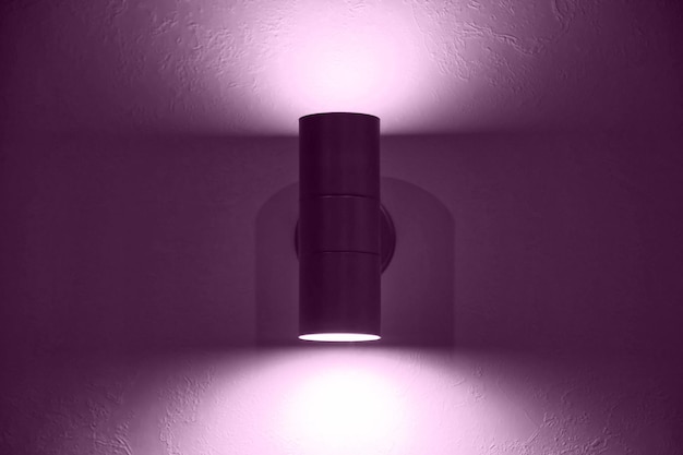 Stylish purple modern lamp on white textured vintage wall Glowing violet chrome led lamp for design interior