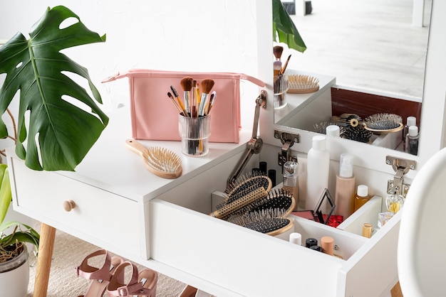 Stylish room interior with elegant dressing table and monstera plants