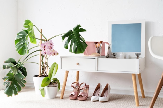 Stylish room interior with elegant dressing table and plants