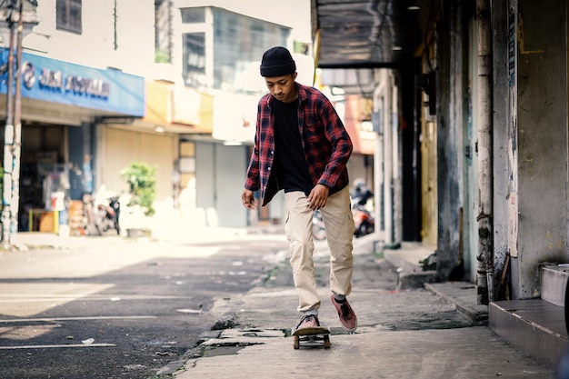 Stylish skater boy riding on skateboard in the pedestrian street