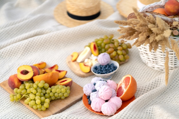 Stylish summer picnic on a white blanket.