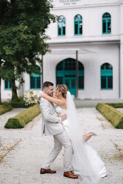 Photo stylish wedding couple posing to photographer in the park newlyweds walking and have fun