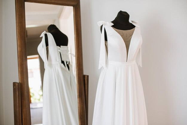 Stylish wedding dress on a mannequin in the morning by the window on the wedding day Preparing for the wedding day