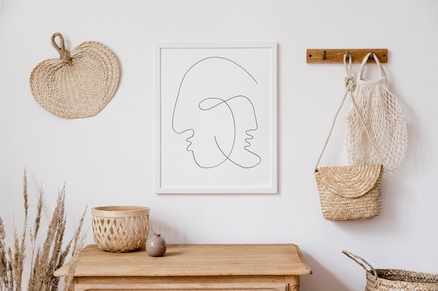 Stylish white interior of living room with mock up poster frame, rattan decoration, leaf, wooden shelf, dried flowers and elegant personal stuff. Neutral concept of home decor. Template.