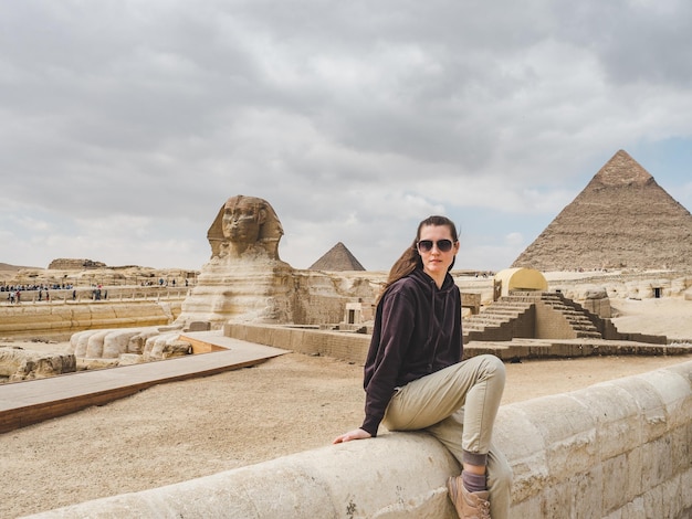 Stylish woman against the background of the Giza pyramid complex