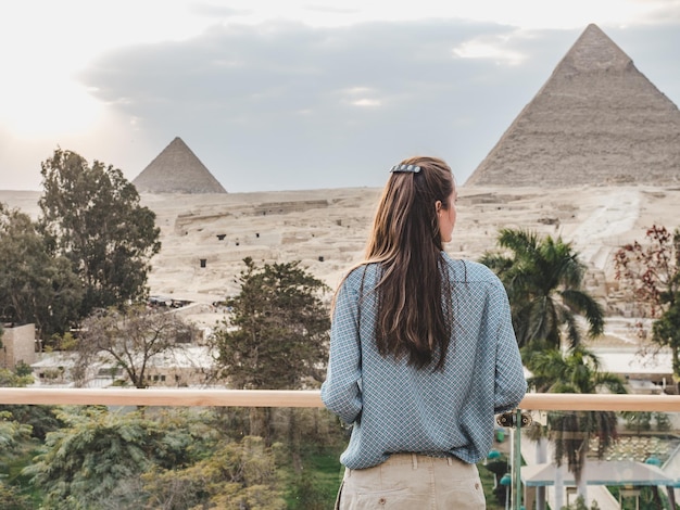 Stylish woman against the background of the Giza pyramid complex