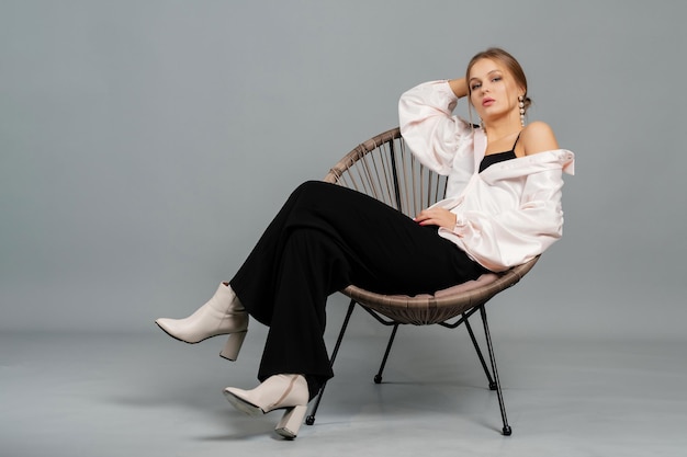 Stylish woman in a blouse and trousers Studio portrait