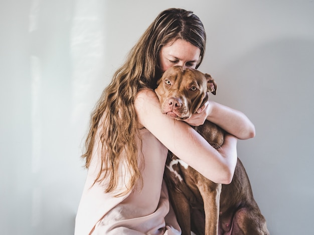 Stylish woman and a charming puppy. Close-up