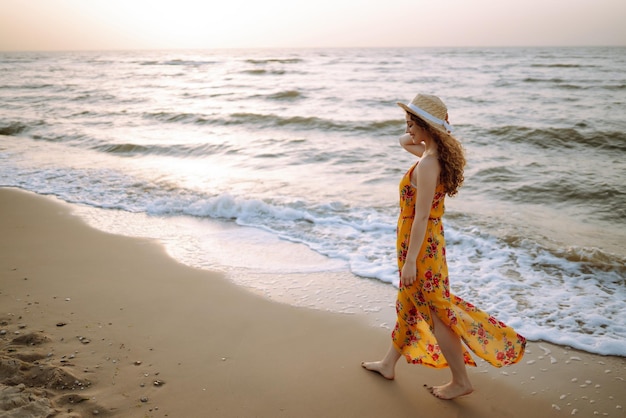 Stylish woman in elegant dress posing near the sea Summer time Travel weekend relax