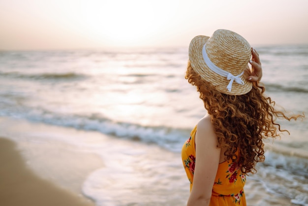 Stylish woman in elegant dress posing near the sea Summer time Travel weekend relax