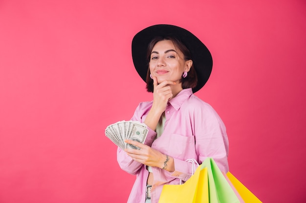 Stylish woman in hat on pink red wall