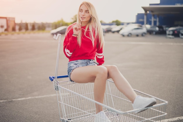 Stylish woman riding shopping cart