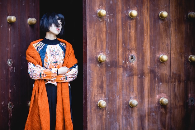 stylish woman standing front of traditional wooden door