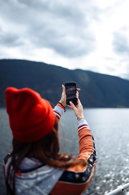 Stylish woman takes a photo on the phone in the travelling The girl tourist photographs