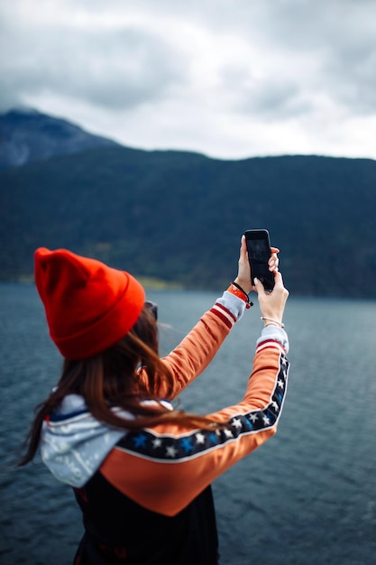 Stylish woman takes a photo on the phone in the travelling The girl tourist photographs