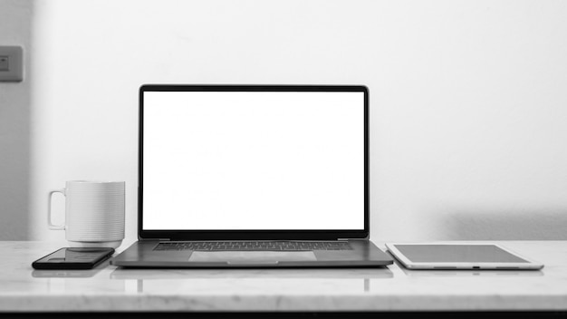 stylish workspace with empty laptop screen white blank and coffee cup.