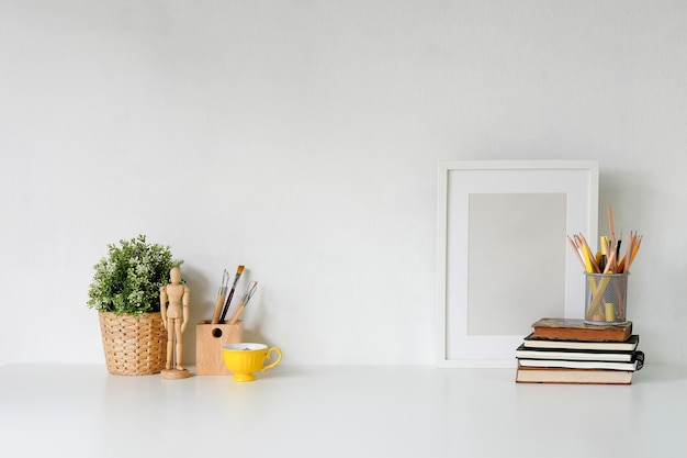 Stylish workspace with poster, book and gadget. Workplace desk and copy space.