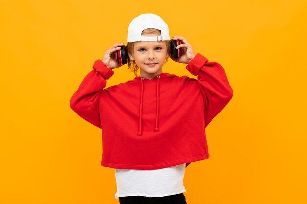 Stylish young boy in red sweatshirt and white t-shirt puts hands on his chest