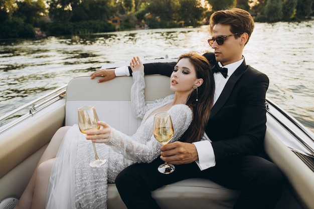 Stylish young bride and groom huging and kissing on yacht