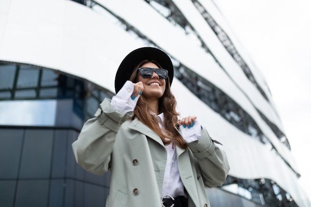 Stylish young elegant woman with a wide smile on her face speaks on a mobile phone on the background