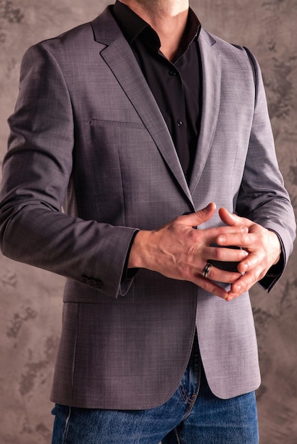 Stylish young handsome businessman in casual gray jacket close up