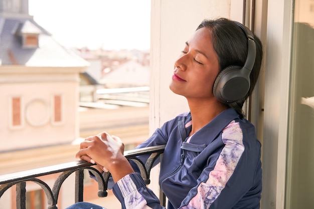 Stylish young Indian woman enjoying music on headphones