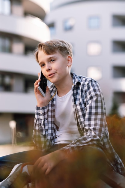 Stylish young man speaks on a smartphone on the street in the city